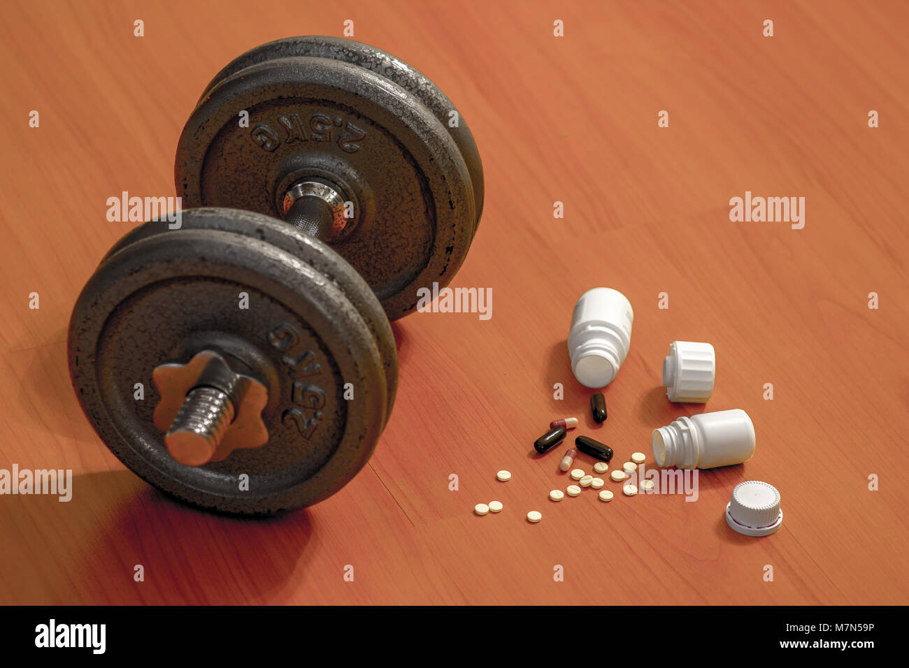 Steroide pillole e capsule con il manubrio peso in background - Il doping nello sport. Foto Stock