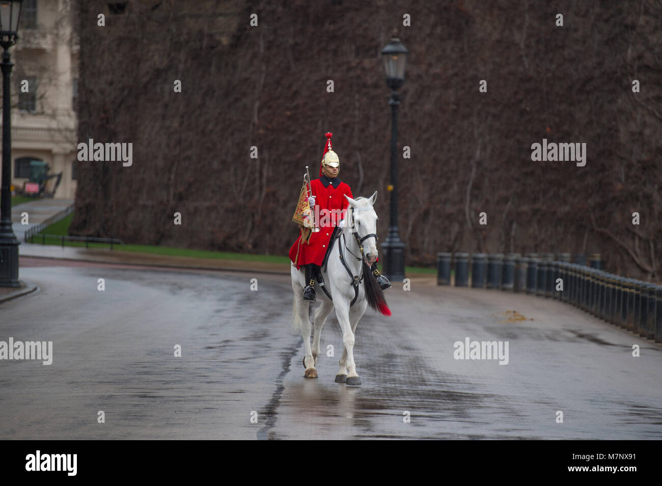 Horse Guards Road, Londra, Regno Unito. Il 12 marzo 2018. Lone montato trumpeter del Blues e Royals passa la cittadella all'inizio della modifica della cerimonia di guardia a prendere posto sulla sfilata delle Guardie a Cavallo su un grigio e umido del mattino. Credito: Malcolm Park/Alamy Live News. Foto Stock