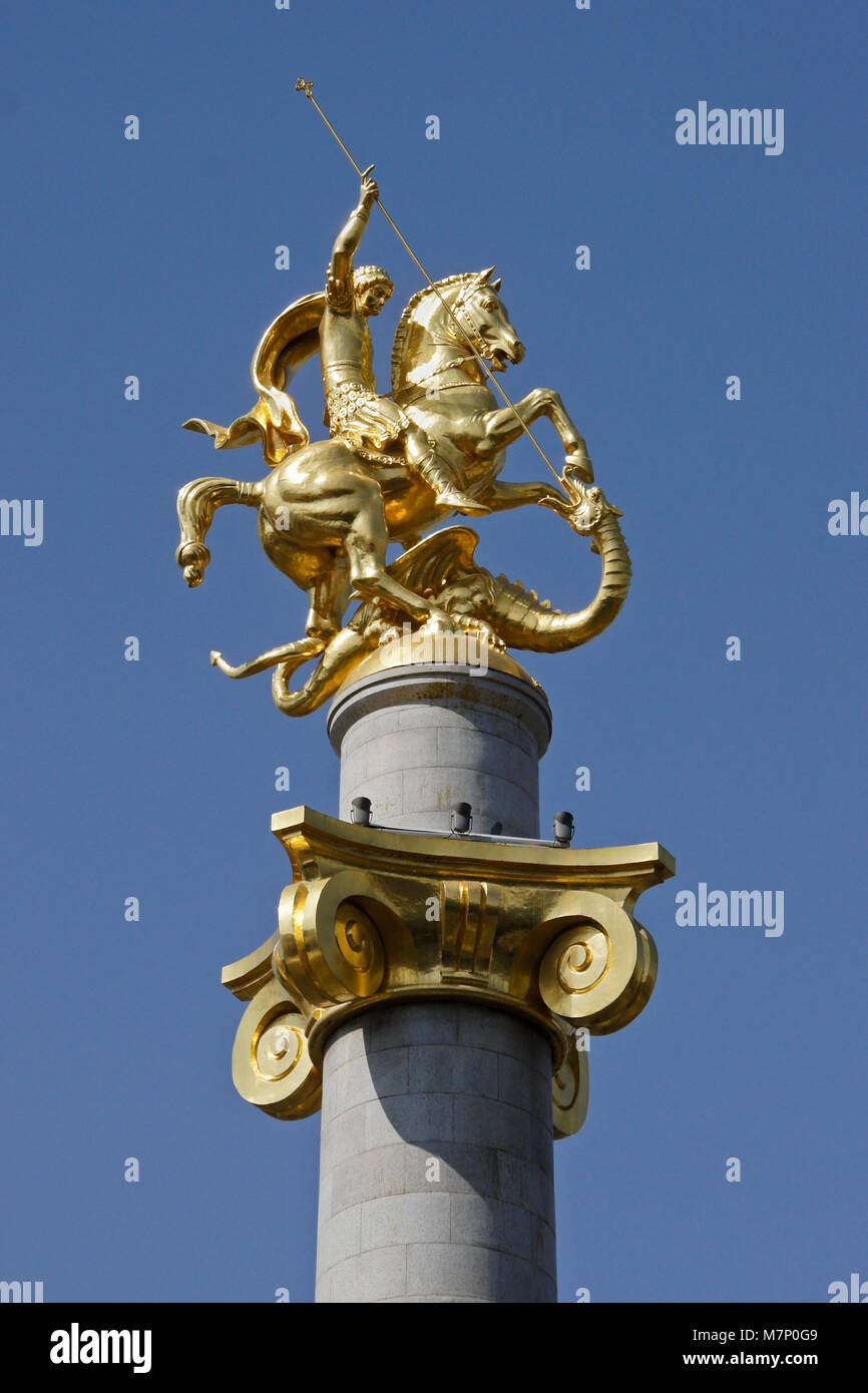 Oro scultura di San Giorgio che uccide il drago in cima ad una colonna in piazza della Libertà, Tbilisi, Georgia Foto Stock