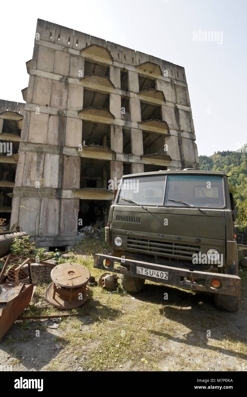 Abbandonato edificio russo e Russo KAMAZ carrello sulla strada di arresto Zizxvari, Svaneti regione del Caucaso, Georgia Foto Stock