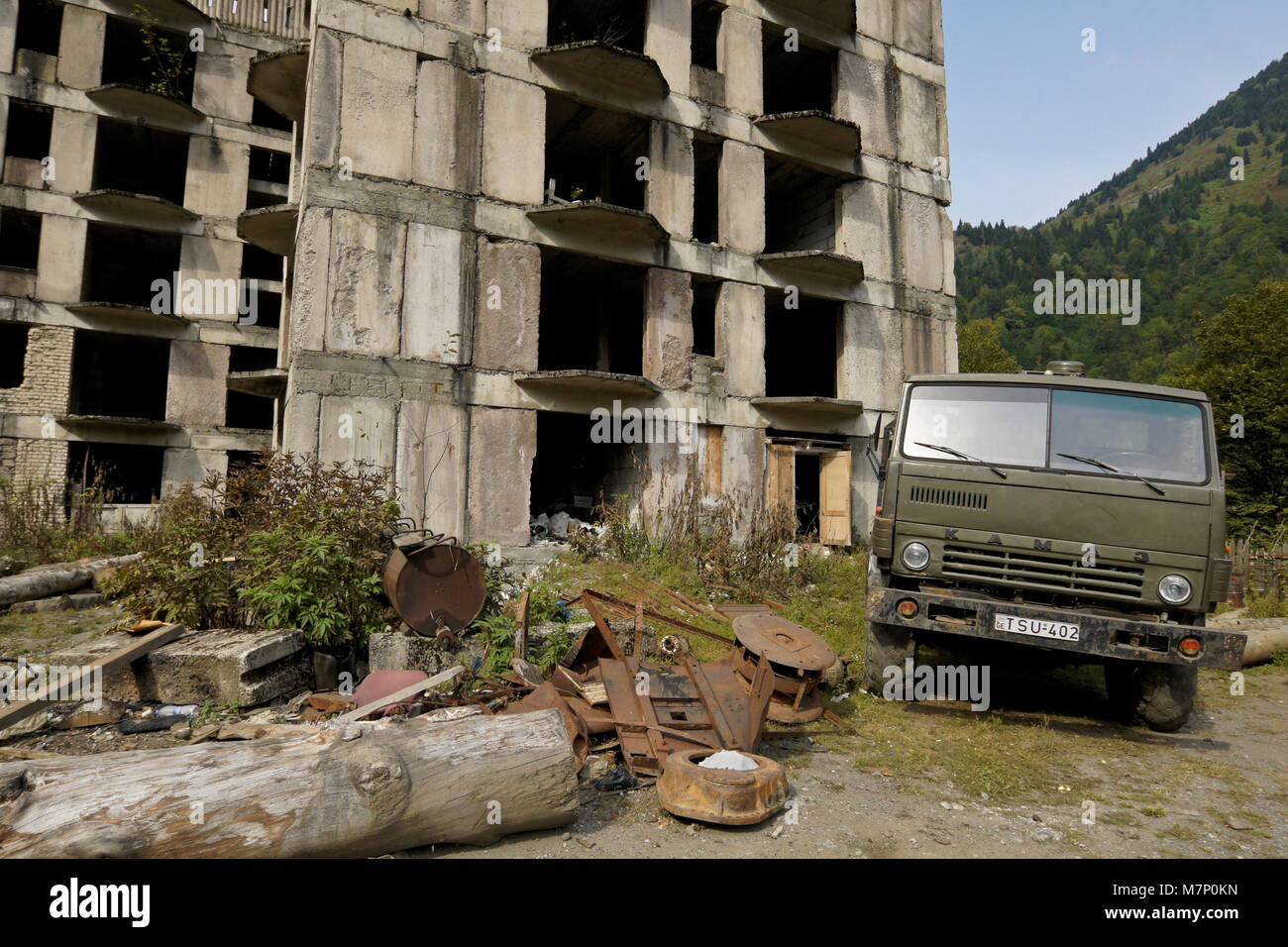 Abbandonato edificio russo e Russo KAMAZ carrello sulla strada di arresto Zizxvari, Svaneti regione del Caucaso, Georgia Foto Stock
