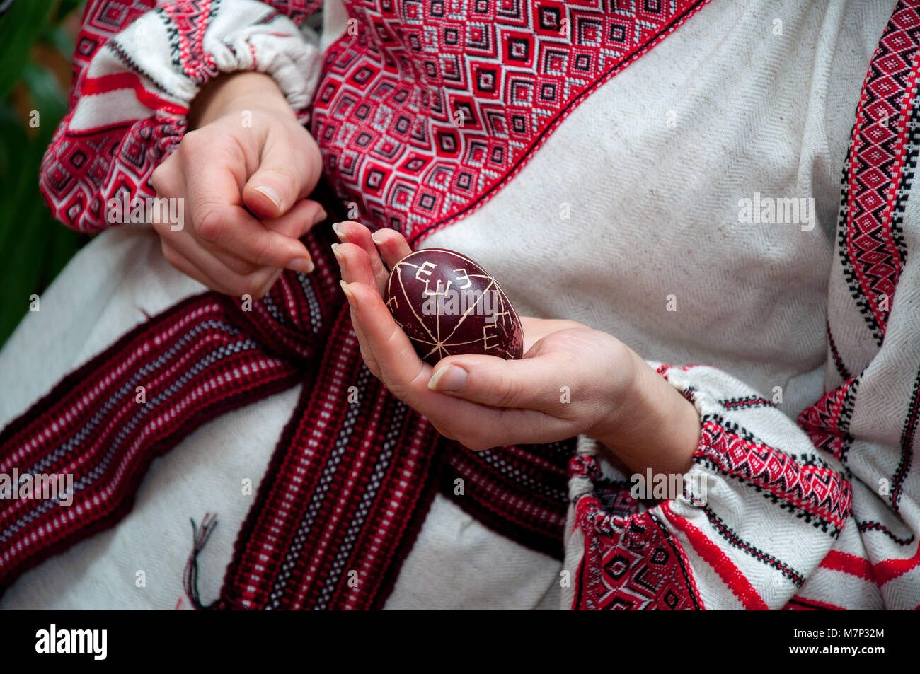 Donna in costume nazionale holding uovo di pasqua Foto Stock