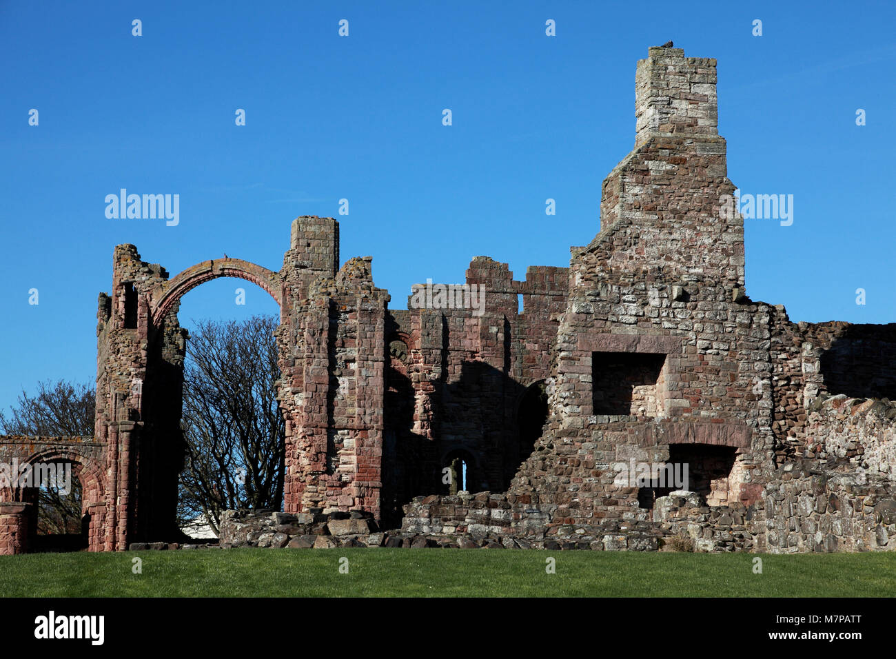 Il "Rainbow arch' e un camino e caminetti in casa di riscaldamento a Lindisfarne Priory Chiesa, Isola Santa. Foto Stock