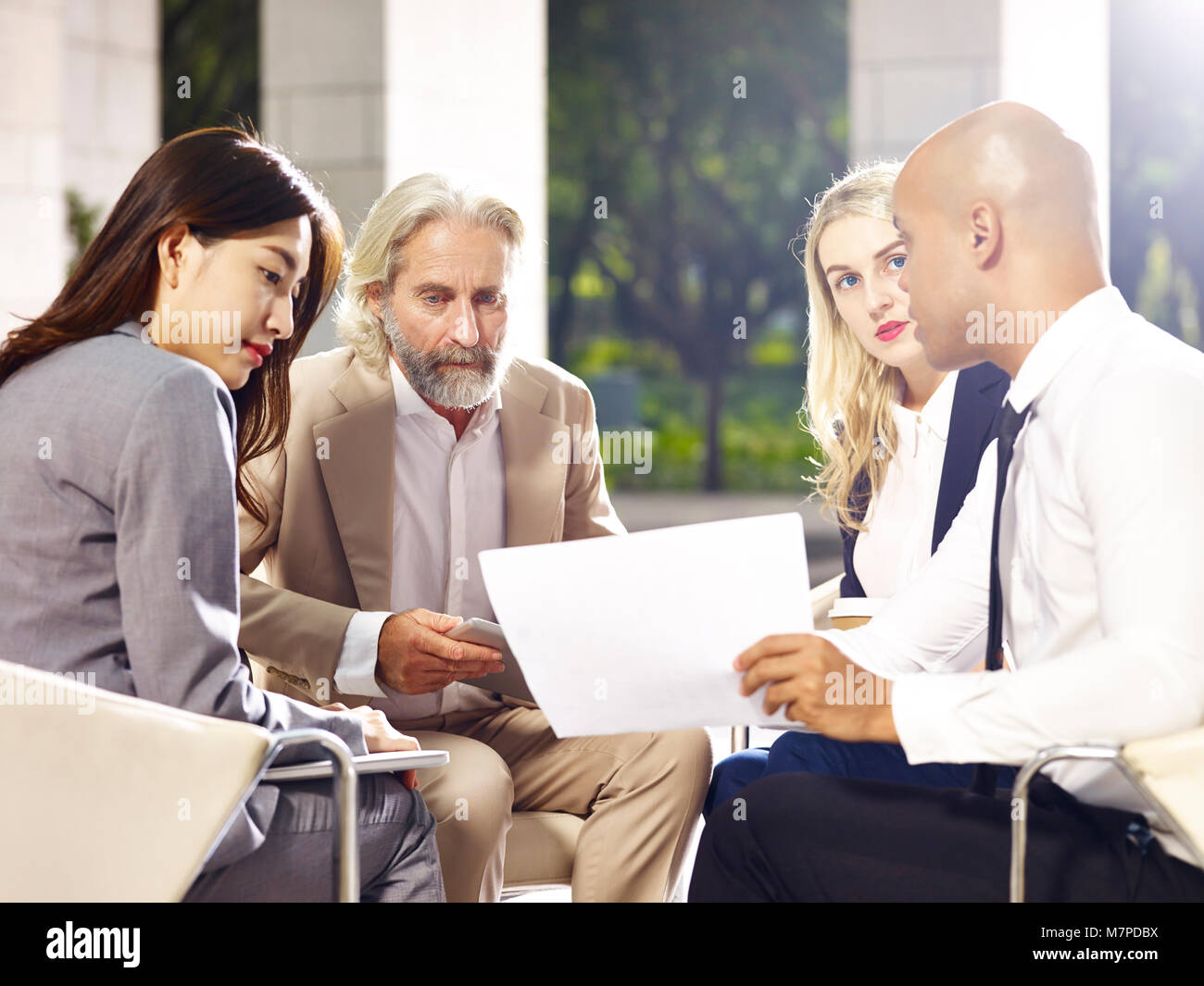 Corporato multietnica persone incontro discutere di affari con computer portatile, in un edificio moderno. Foto Stock