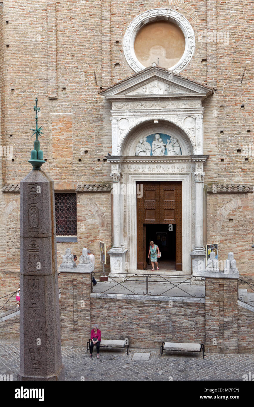 Urbino, Italia - 14 Giugno 2017: la gente alla chiesa gotica di San Domenico e obelisco egiziano. Questa è una delle dodici originale di obelischi egiziani Foto Stock