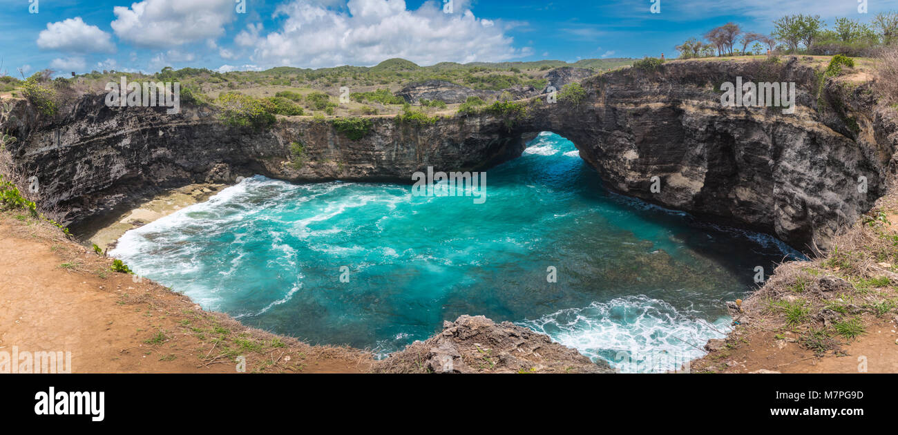 La bellezza panoramica di rotture di spiaggia con grandi onde a Nusa Penida, Indonesia Foto Stock