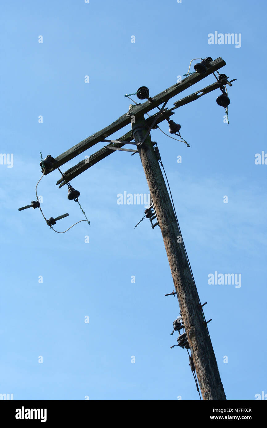 Un vecchio palo telefonico contro il cielo blu Foto Stock