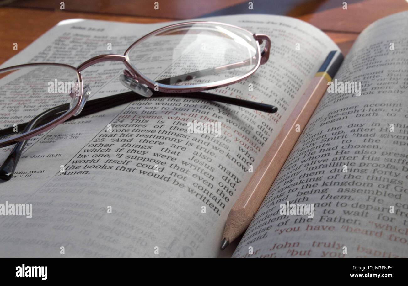 La Bibbia con gli occhiali e matita Foto Stock