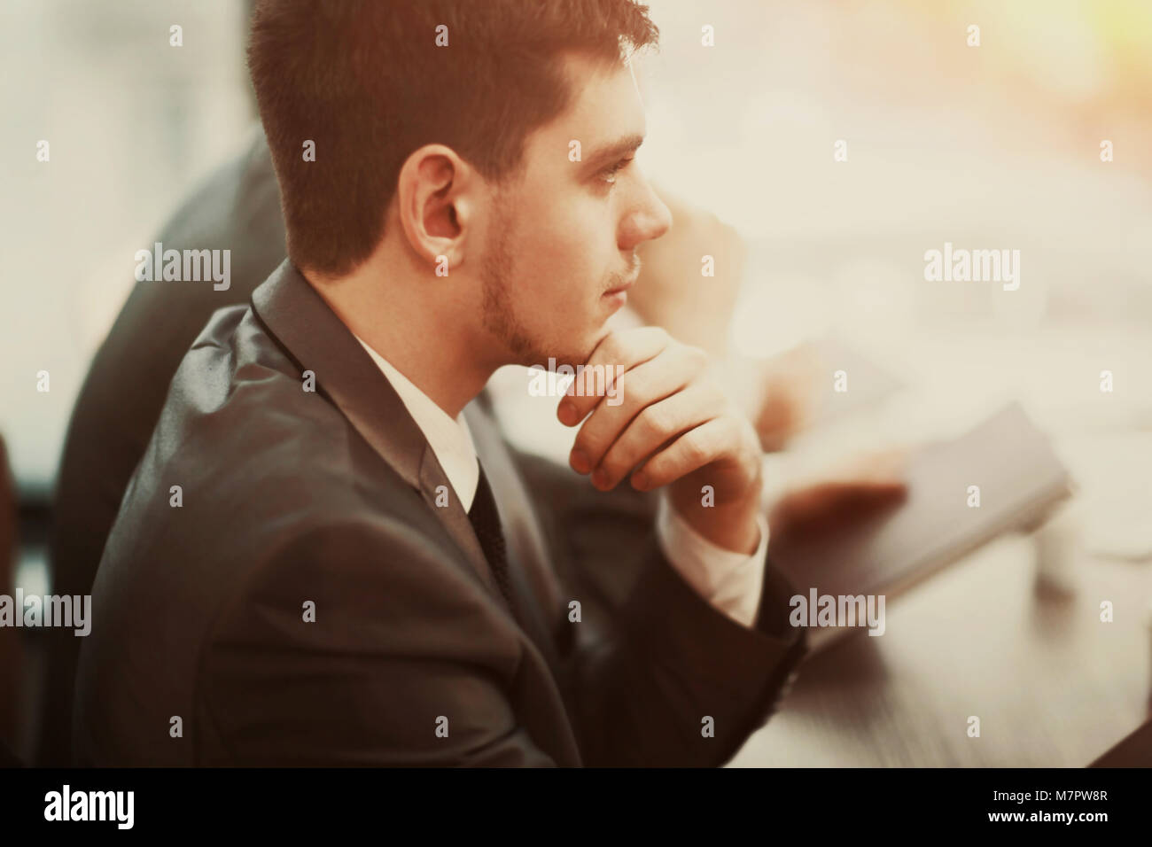 Imprenditore Casual pensando con il team dietro di lui in ufficio Foto Stock