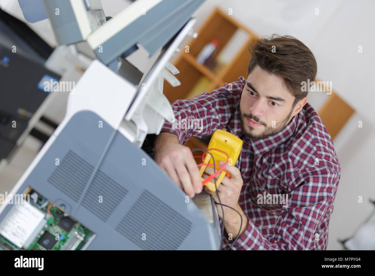 Giovane tecnico utilizzando il multimetro Foto Stock