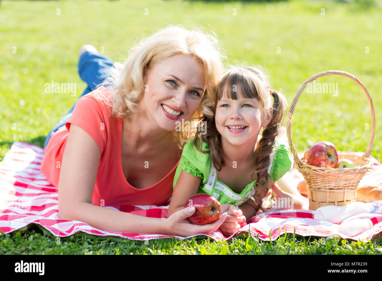 La famiglia felice - madre e figlia sul prato erboso. Vacanze estive. Foto Stock