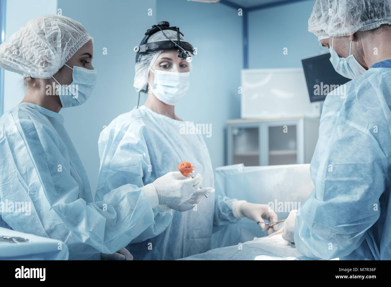 Affidabile infermiera grave e permanente tenendo un morsetto. Foto Stock