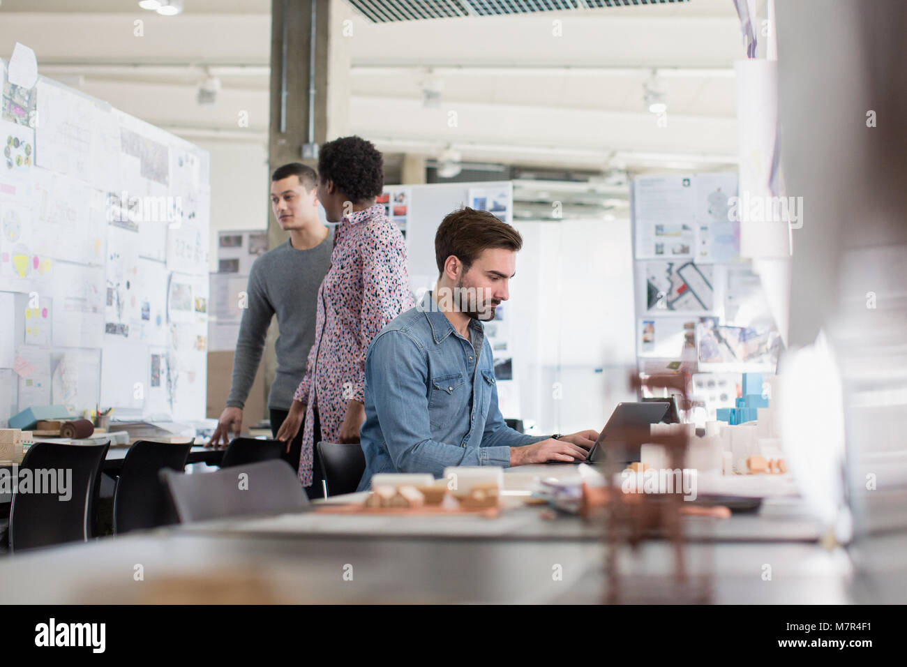 Designer che lavorano in un piano aperto spazio in ufficio Foto Stock