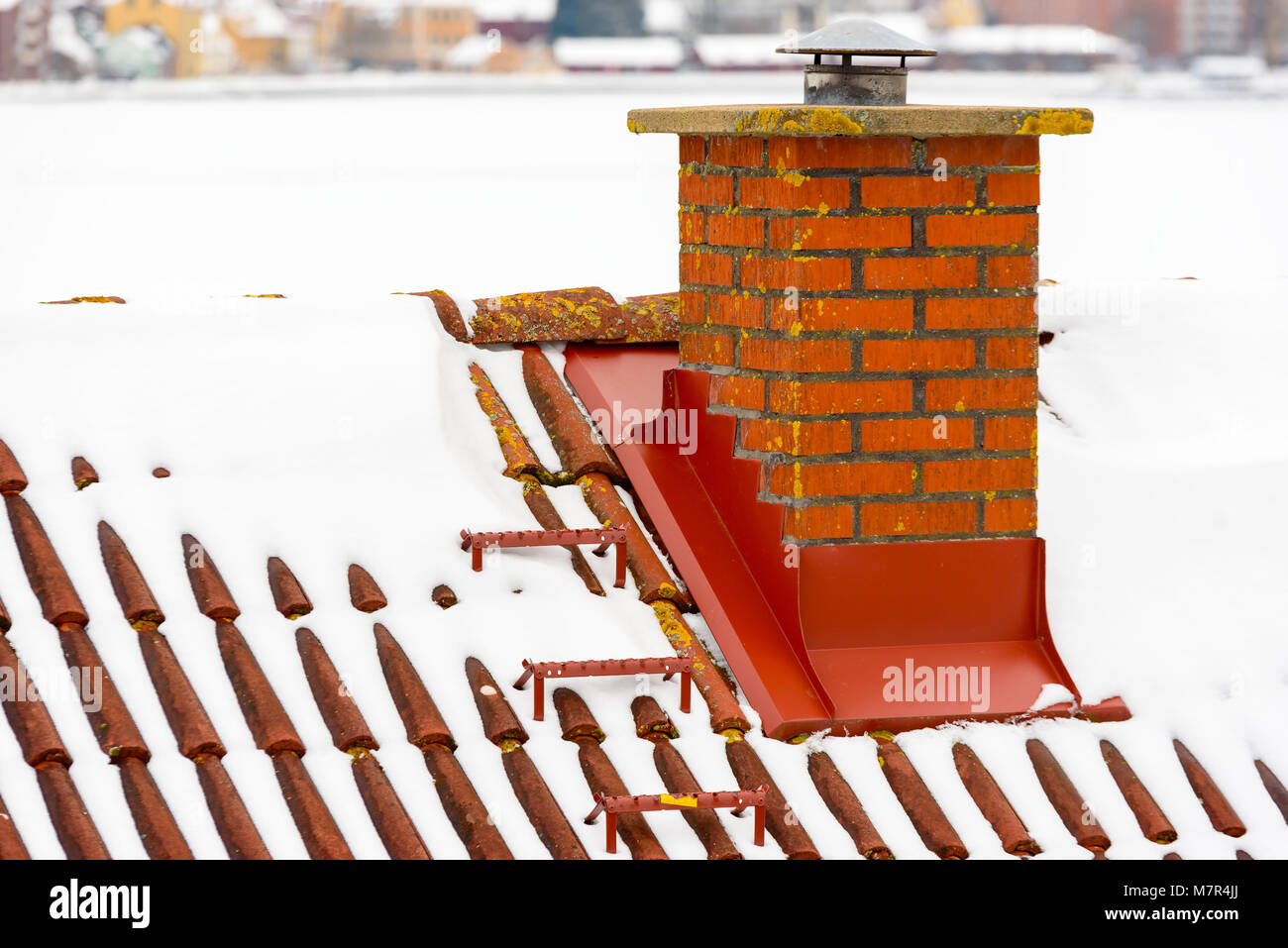 Mattone rosso camino sul tetto in inverno. Foto Stock