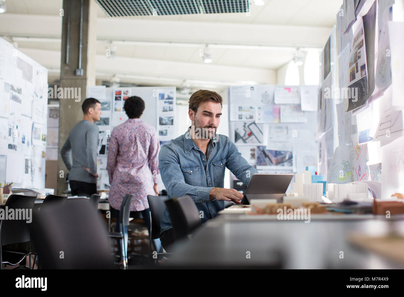 Designer che lavorano in un piano aperto spazio in ufficio Foto Stock