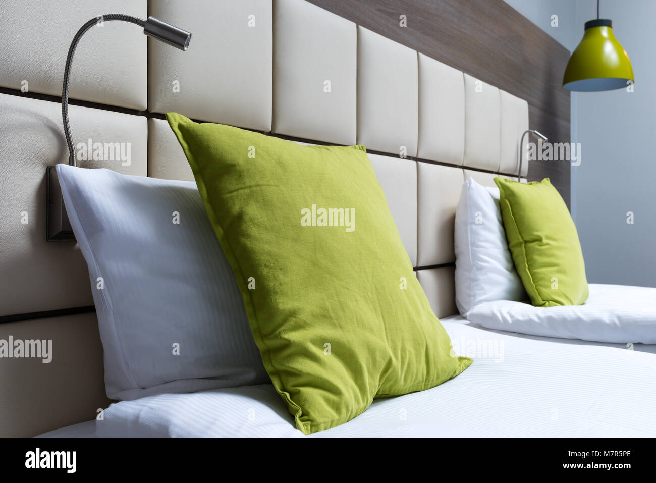 Cuscino verde, lampade da lettura e cuoio testiera del letto in camera da  letto moderna Foto stock - Alamy