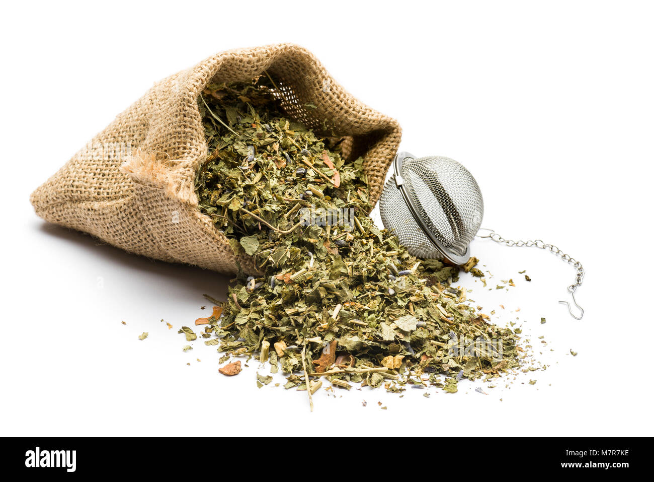 Il tè verde miscela in juta Sacco con infusore su sfondo bianco Foto Stock