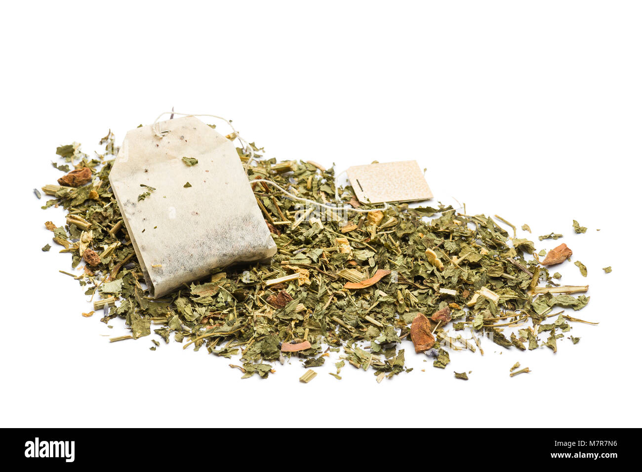 Cumulo di tè verde miscela con un sacchetto da tè su sfondo bianco Foto Stock