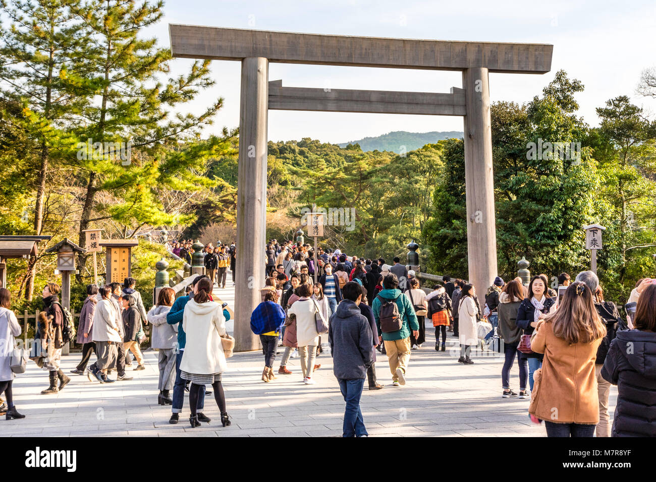 Giappone, Ise Grand Santuario Naiku, santuario interiore. Torii gate e ponte che conduce oltre il fiume al santuario, molte persone a piedi attraverso. Durante il giorno, l'inverno. Foto Stock