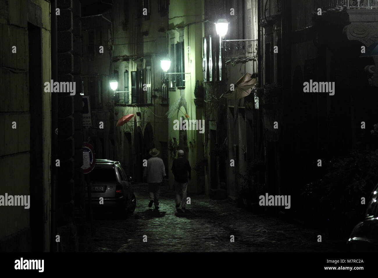 Due uomini a piedi di notte, downtown, Vetralla, Viterbo, Italia Foto Stock