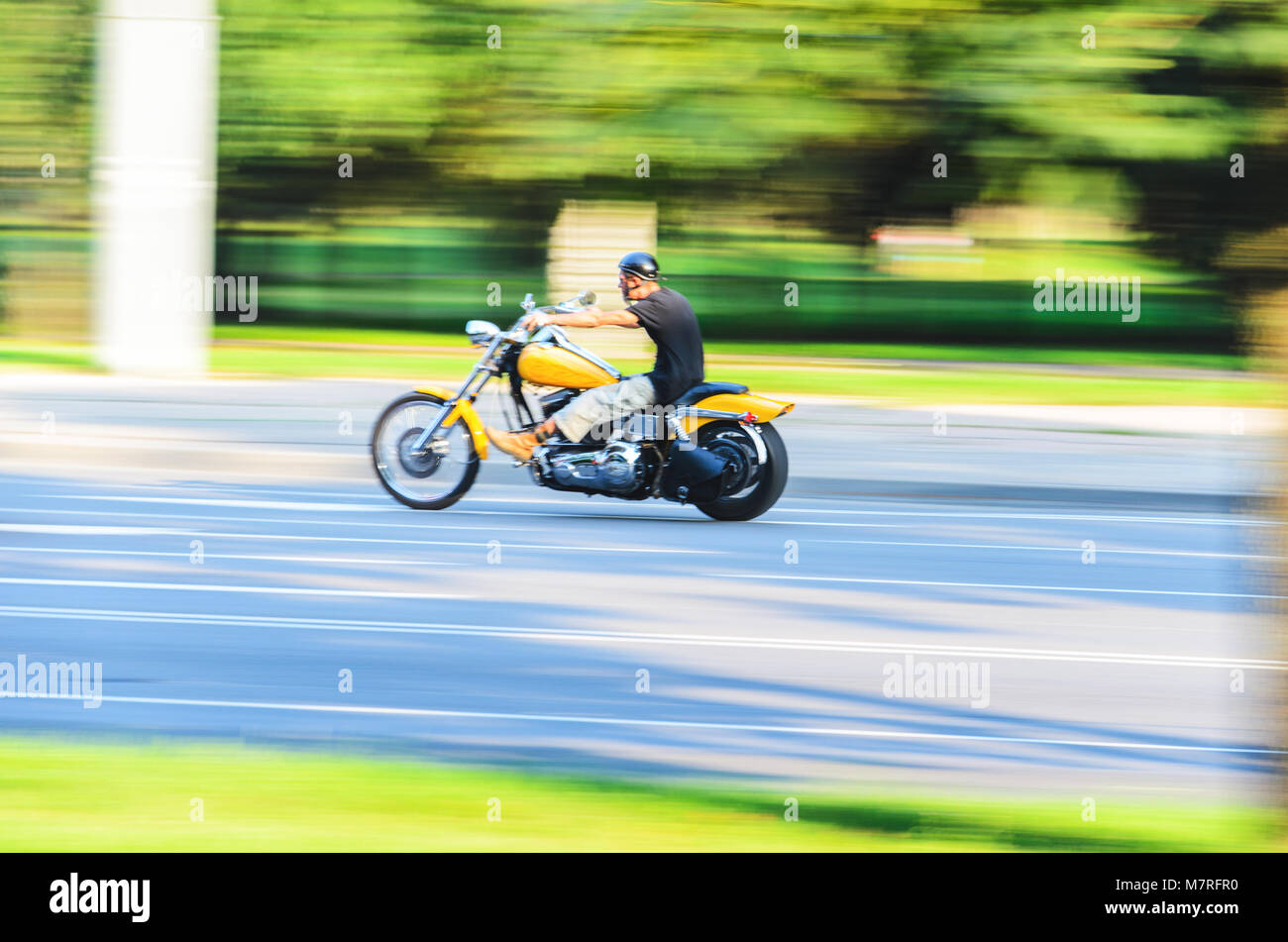 Abstract Motion Blur, biker moto equitazione, Driver Racing sul grande giallo Bike, vista laterale, Sfocatura Movimento, Estate Road Trip, il concetto di velocità Foto Stock