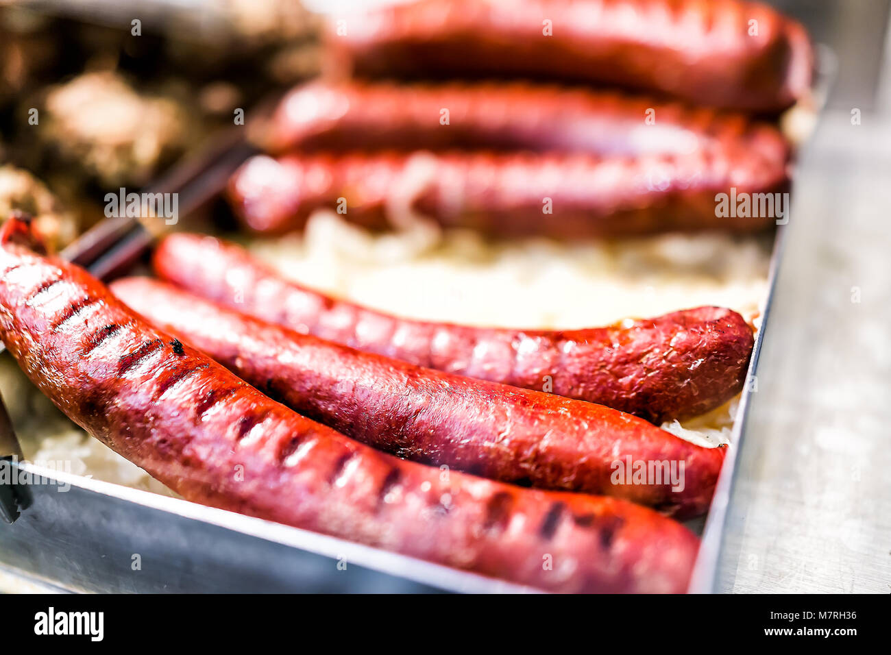 Hot Dog salsicce kielbasa grill segna grigliate di arrosto di rosa rosso grandi nel vassoio sul display nella deli, catering, banco buffet macro closeup che mostra il dettaglio Foto Stock