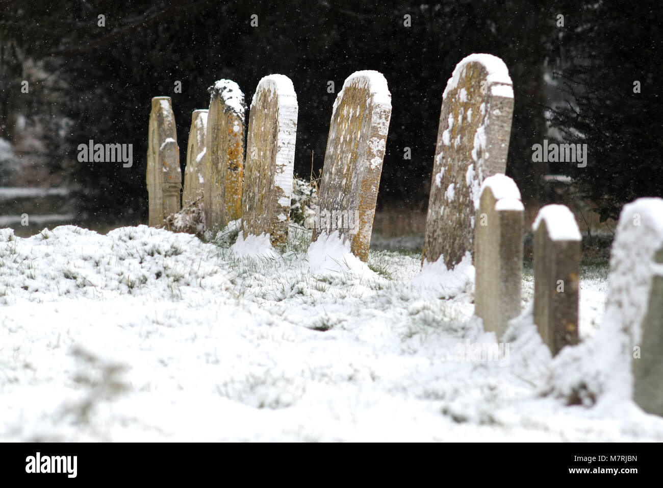 Coperta di neve cimitero in un villaggio chiesa mature, East Sussex. Foto Stock