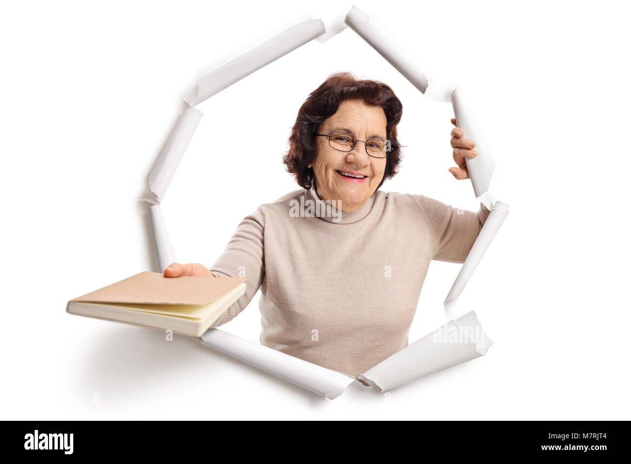 Donna anziana rottura attraverso la carta e dando un libro Foto Stock