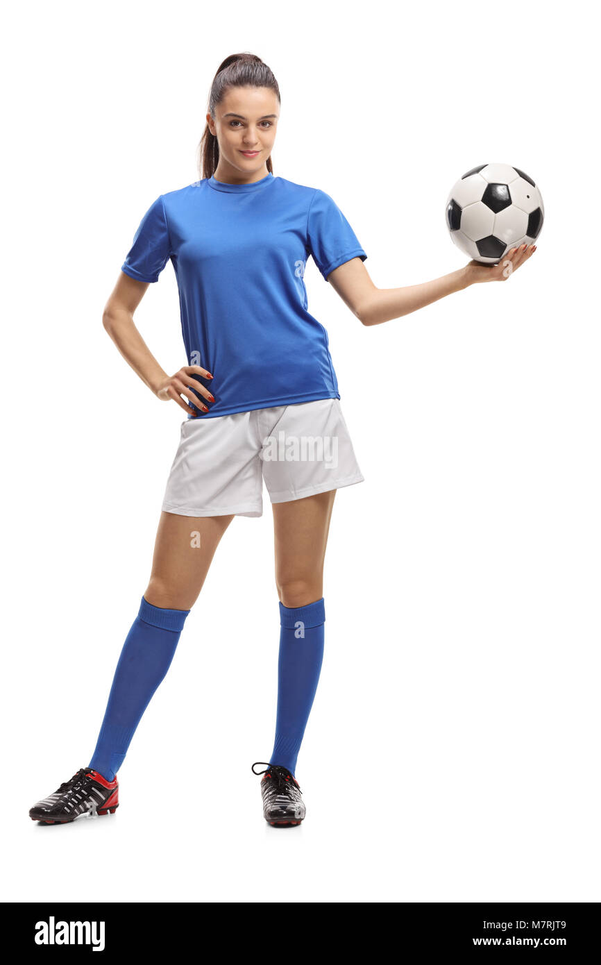 A piena lunghezza verticale di una femmina di giocatore di calcio tenendo un calcio isolati su sfondo bianco Foto Stock