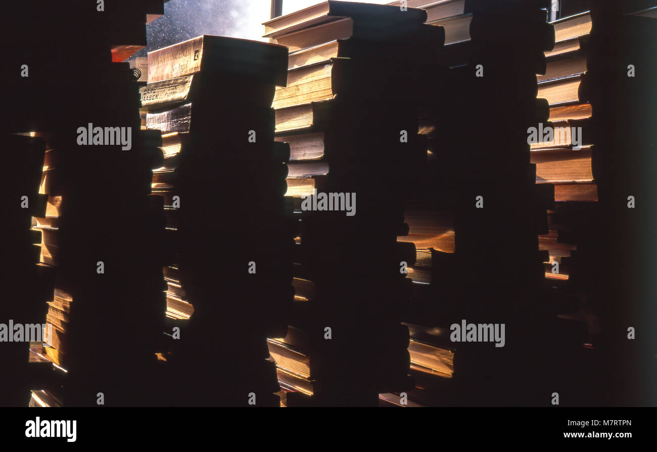 Pile di libri su un davanzale in controluce. Foto Stock