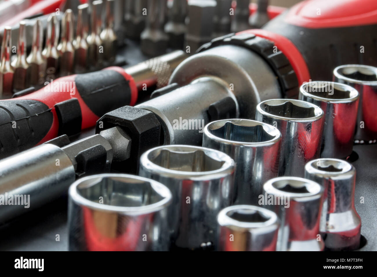 Un insieme di teste metalliche con il bit di chiave e cacciavite dentro la cassetta degli attrezzi. Foto Stock