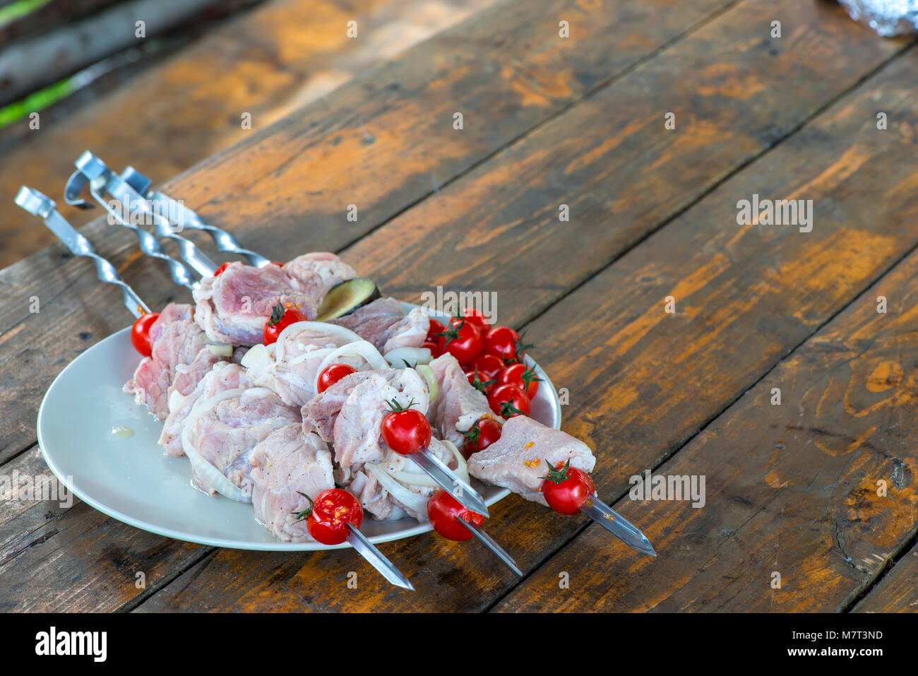 Su un tavolo di legno una piastra con materie shish kebab spiedini su Foto Stock