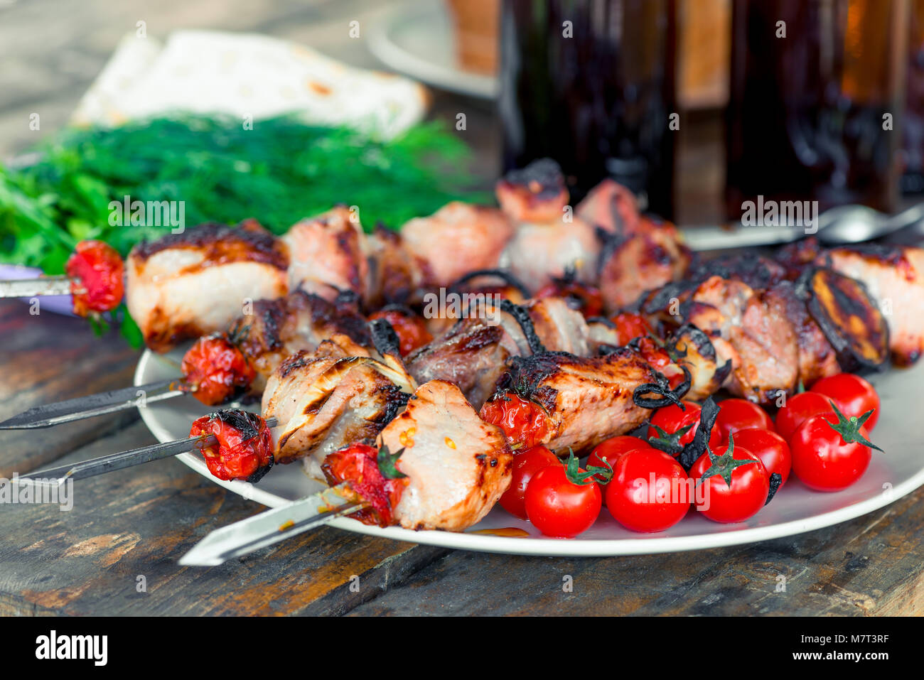 Carne di maiale aromatizzata shish kebab con verdure su spiedini di close-up sul tavolo Foto Stock