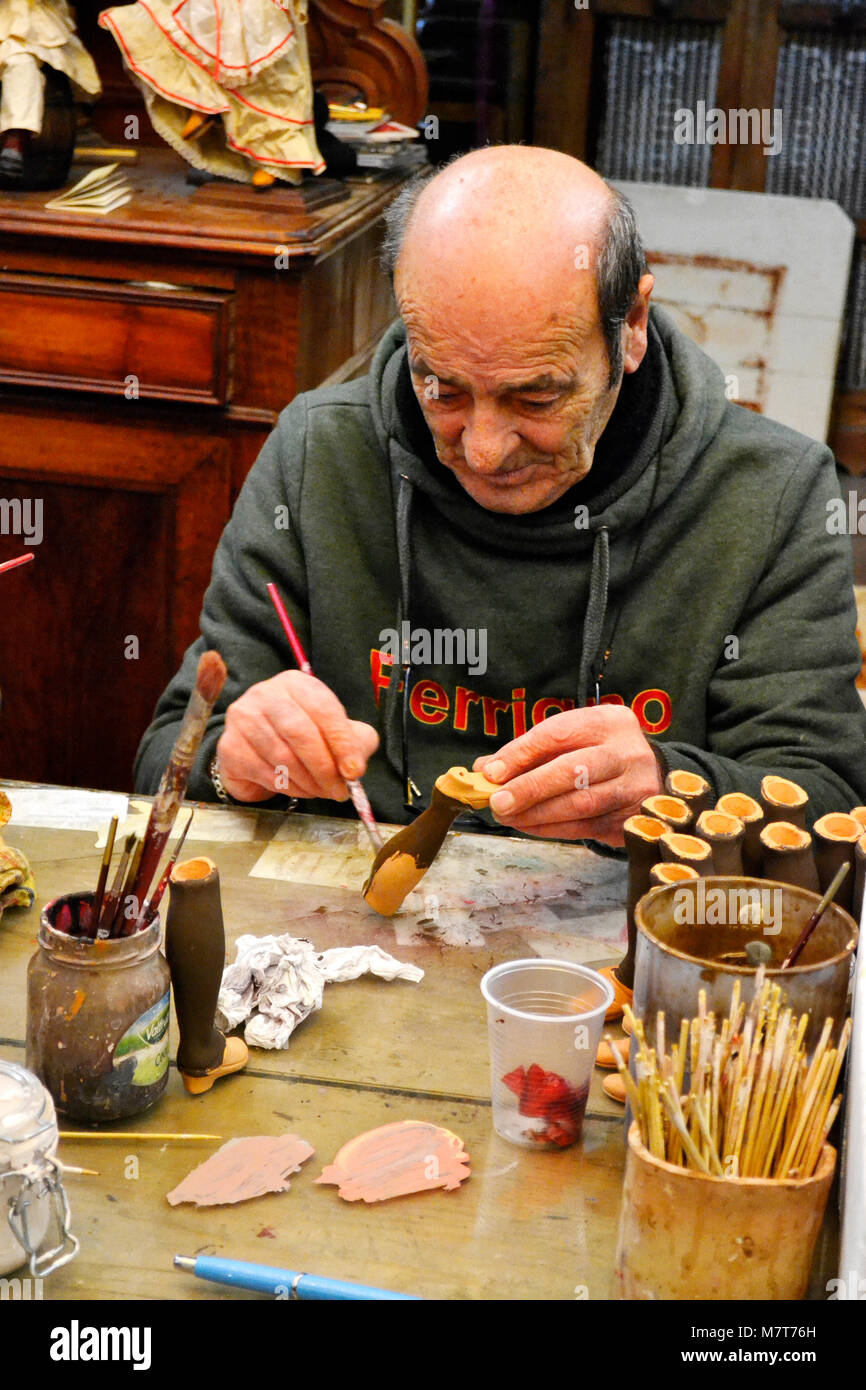 Un artista che lavora sul artigianale di figure per presepi in 'Ferrigno Marco' officina, Via San Gregorio Armeno a Napoli. Foto Stock