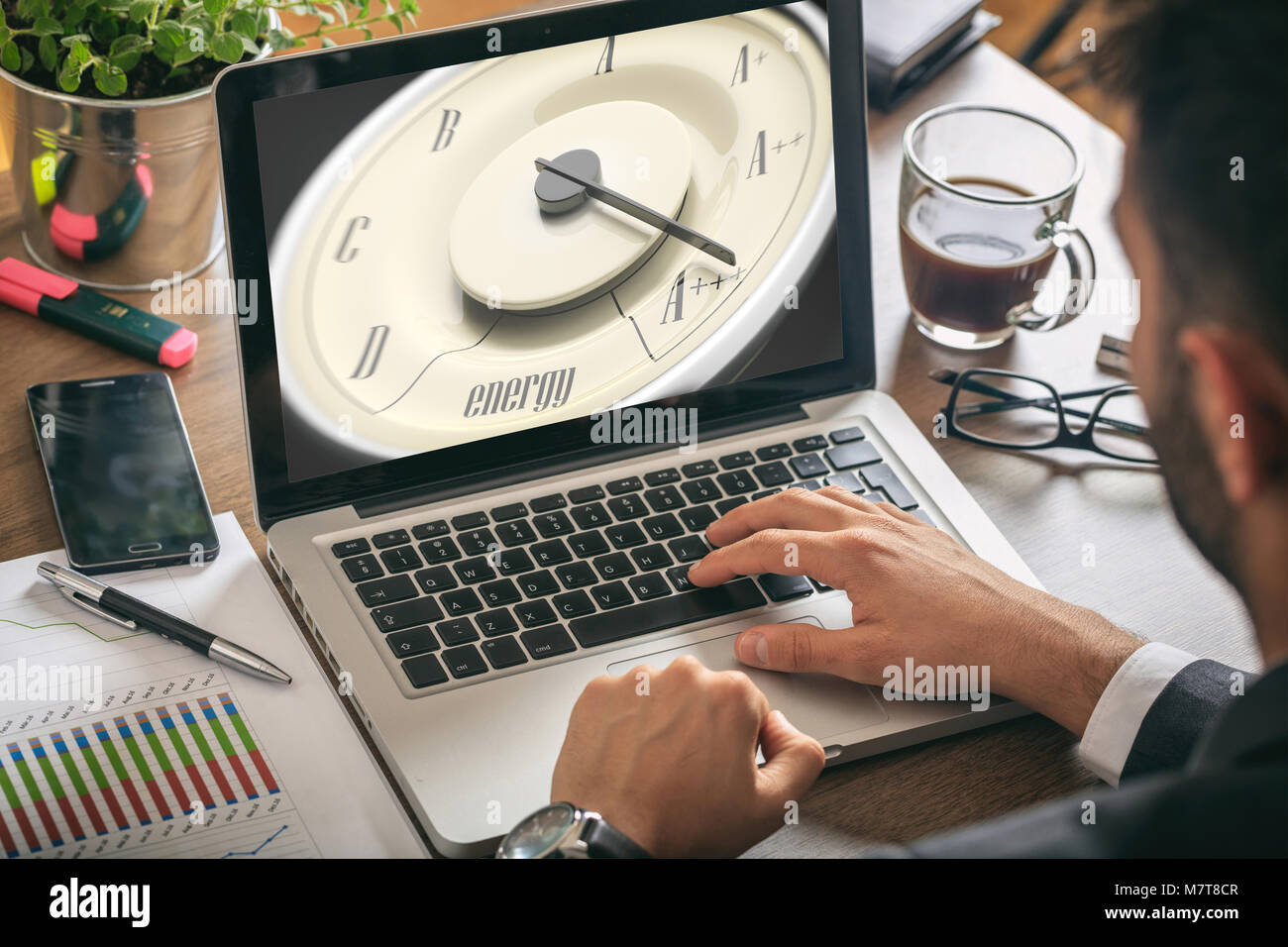 Efficienza energetica del concetto. Auto d'epoca, indicatore sullo schermo di un computer, l'uomo lavora, sullo sfondo di office Foto Stock