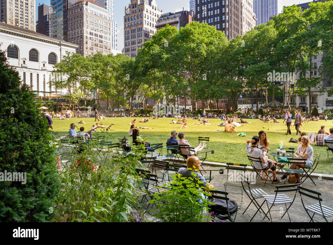 Le persone che godono di una giornata estiva nel Bryant Park un parco cittadino nel centro di Manhattan, New York City, NY, USA Foto Stock