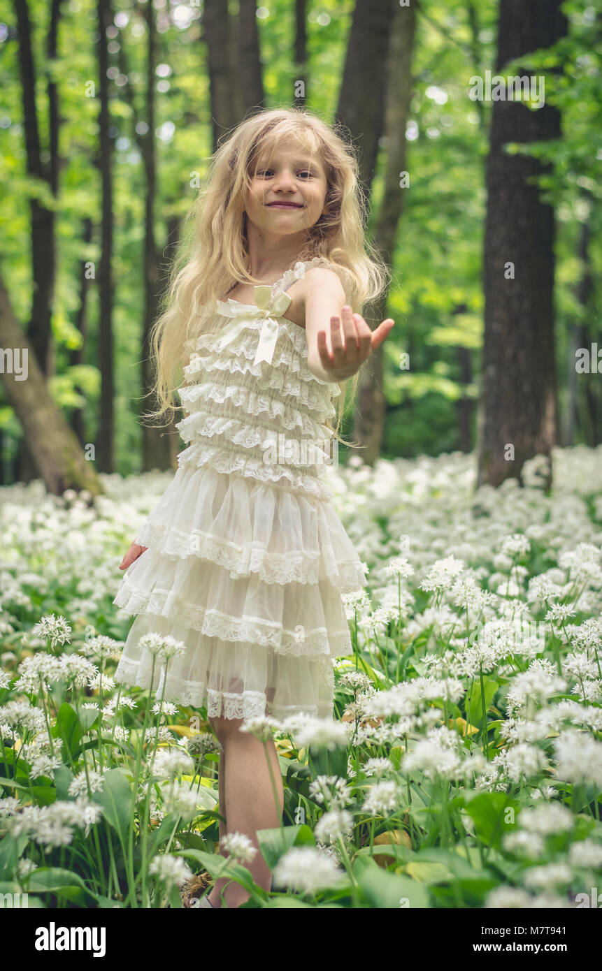 Bella fata ragazza con lunghi capelli biondi nella foresta di primavera Foto Stock