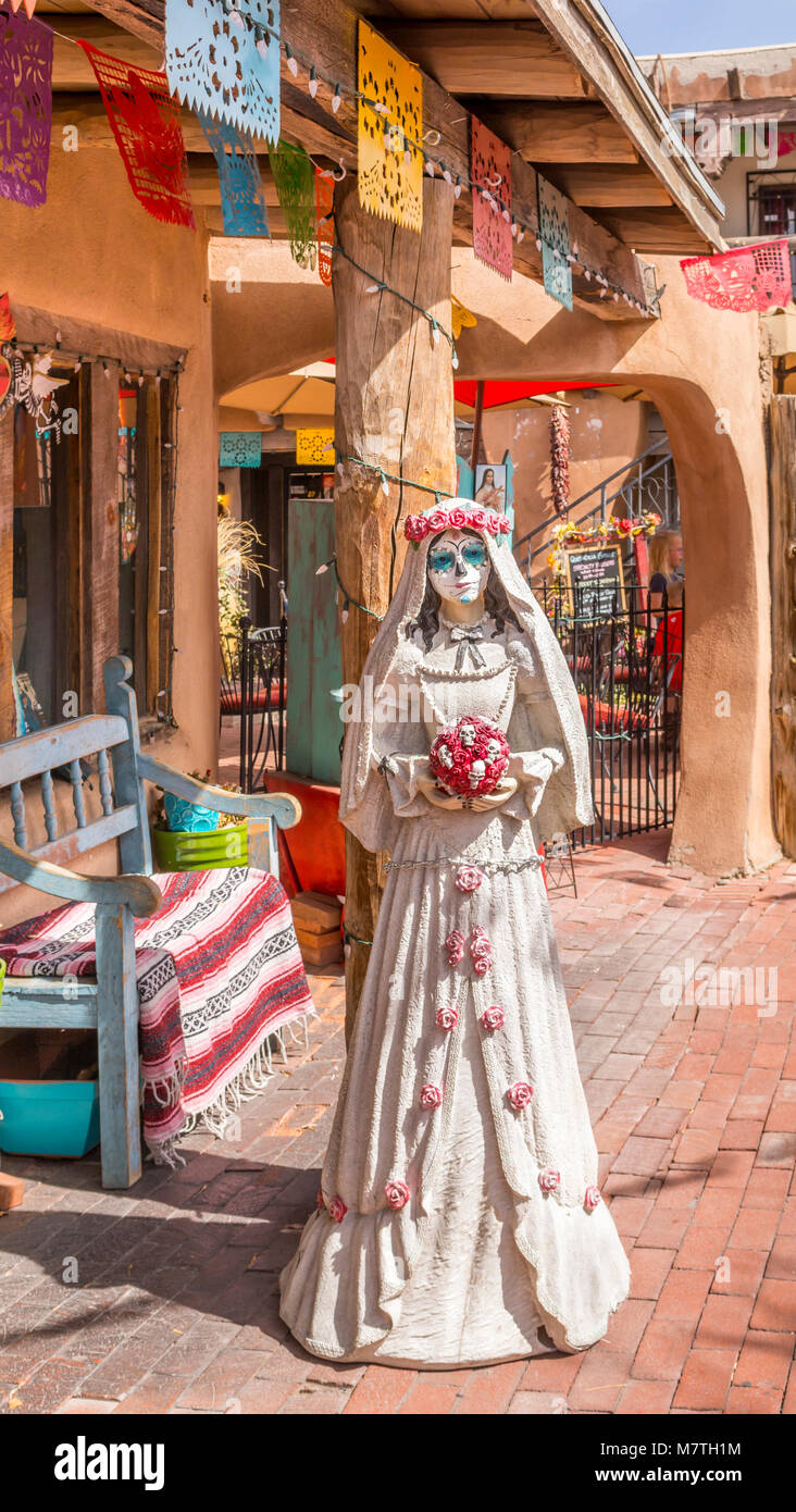Il giorno dei morti sposa tenendo un bouquet di teschi e le rose di fronte un colorato negozio di souvenir in Albuquerque Old Town Plaza, Nuovo Messico, STATI UNITI D'AMERICA, Foto Stock