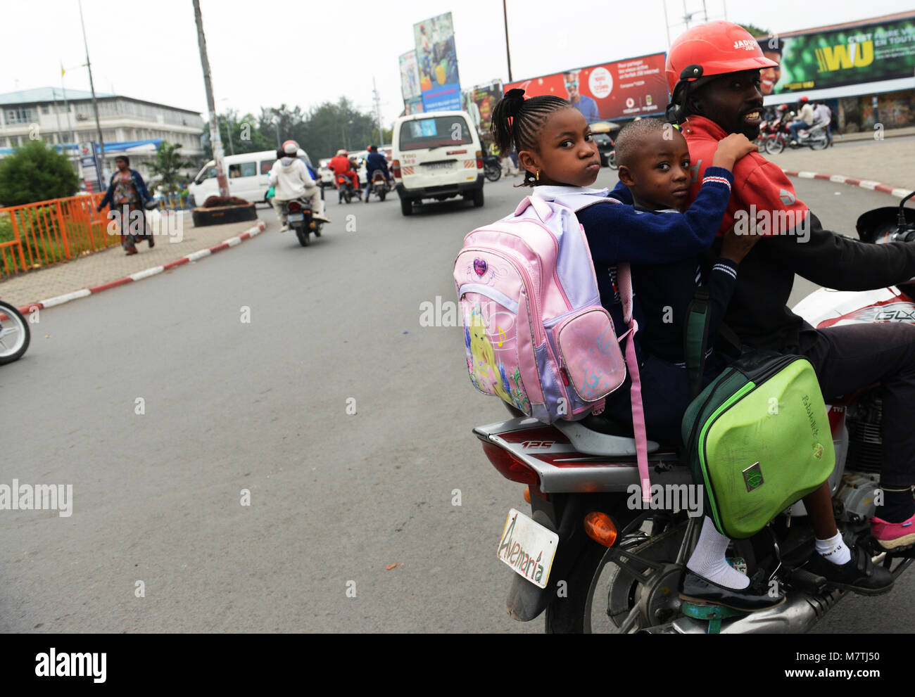 La guida i suoi figli sulla sua moto. Foto Stock