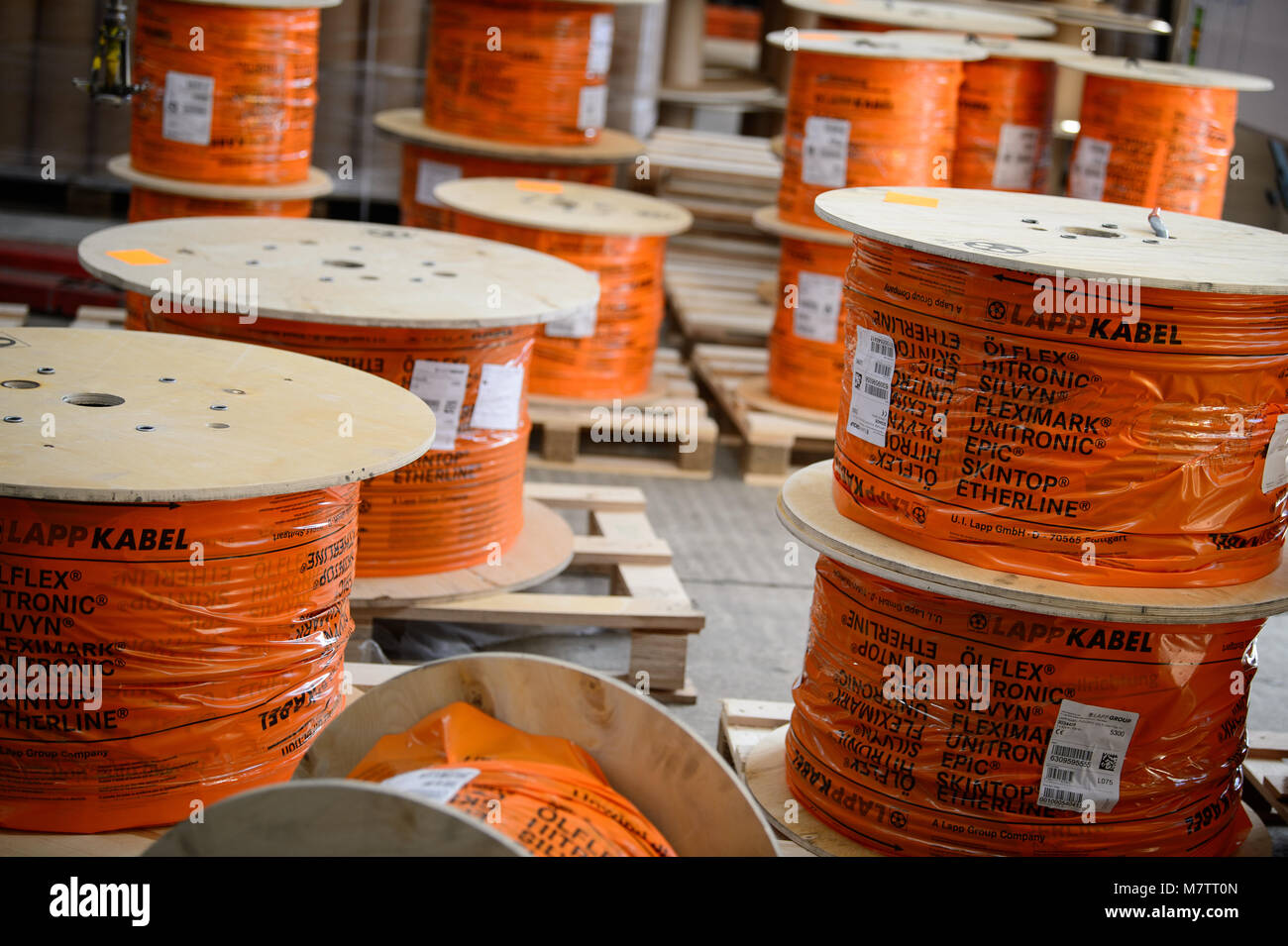 08 marzo 2018, Germania, Stuttgart-Vaihingen: arrotolati dei cavi del produttore di cavi Lapp vengono memorizzati in una hall. Lapp può avere beneficiato degli elevati prezzi del rame nell'anno passato. L'azienda di famiglia che appartiene ai maggiori produttori mondiali di cavi industriali, sta per avere la sua dichiarazione finanziaria conferenza stampa martedì (13 marzo 2018) a Stoccarda. Foto: Sina Schuldt/dpa Foto Stock