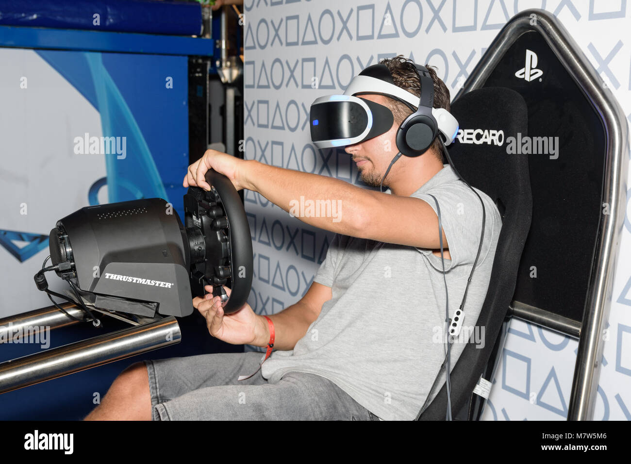 Colonia, Germania - 24 agosto 2017: una fiera che il visitatore è la riproduzione di un gioco di corse con vr headeset e speciale dispositivo a Gamescome 2017. Foto Stock