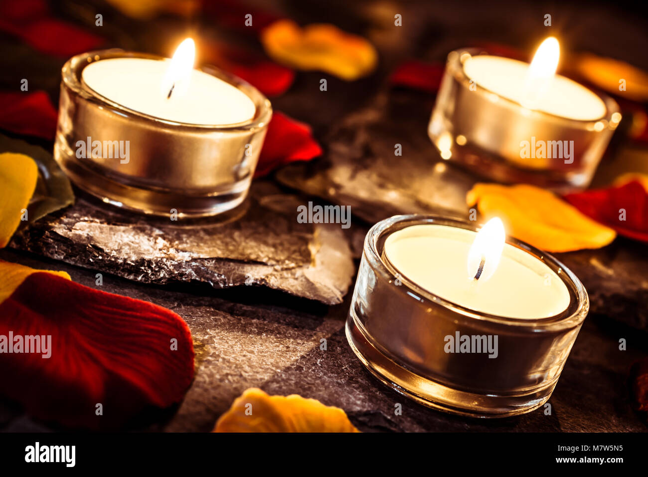 2 candele romantiche su ardesia con petali di rosa e foglie Foto