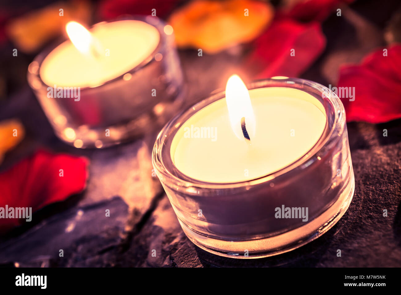 2 candele romantiche su ardesia con petali di rosa e foglie Foto stock -  Alamy