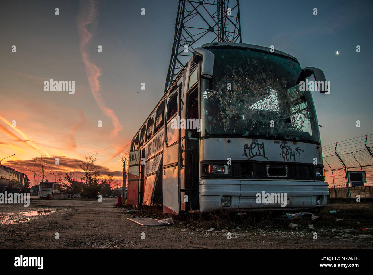 Rusty bus abbandonato e il sorgere del sole Foto Stock
