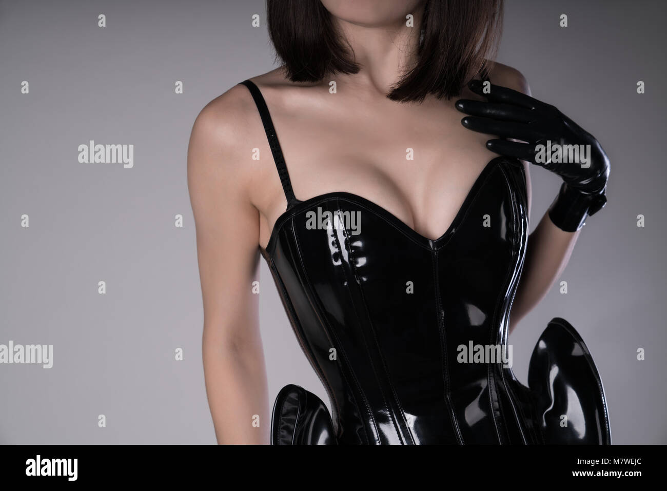 Sensuale donna vestita di nero stile fetish corsetto e guanti, studio shot  Foto stock - Alamy