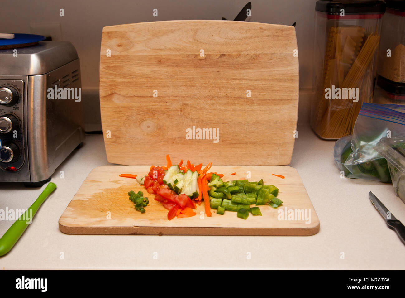 Banco di cucina con area per la preparazione di cibi con tagliere, coltello, verdure Foto Stock