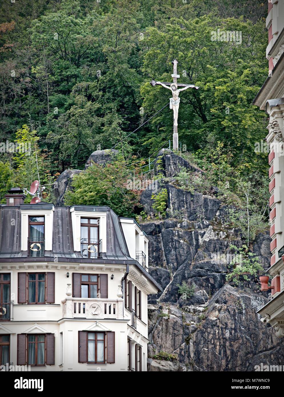 Cristo sulla croce sopra le case in KARLOVA VARIARE CHZECH REPUBBLICA Foto Stock