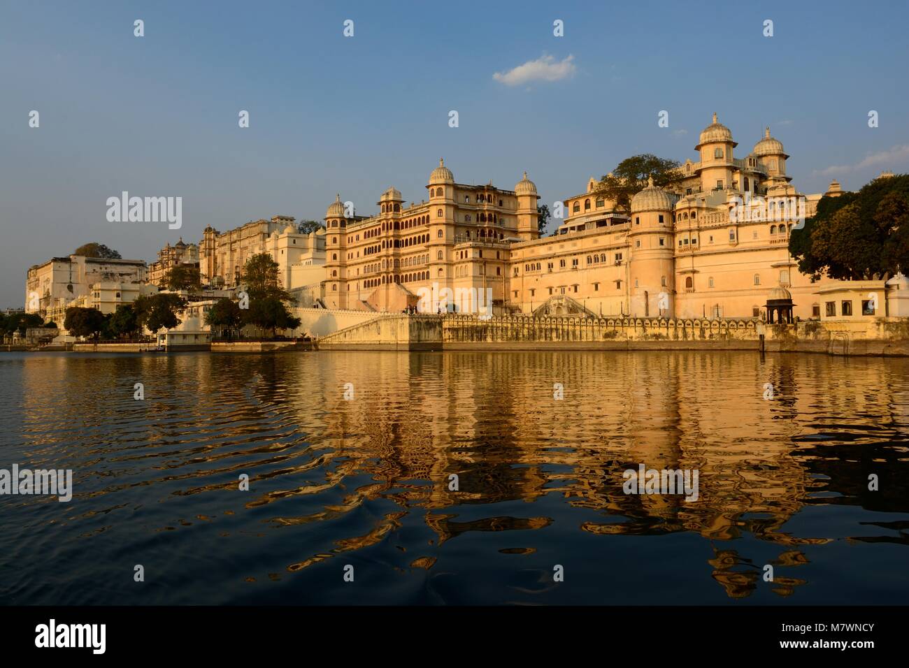 Palazzo di città si riflette nel lago Pichola al tramonto il più grande complesso di palazzo in Rajasthan Udaipur India Foto Stock