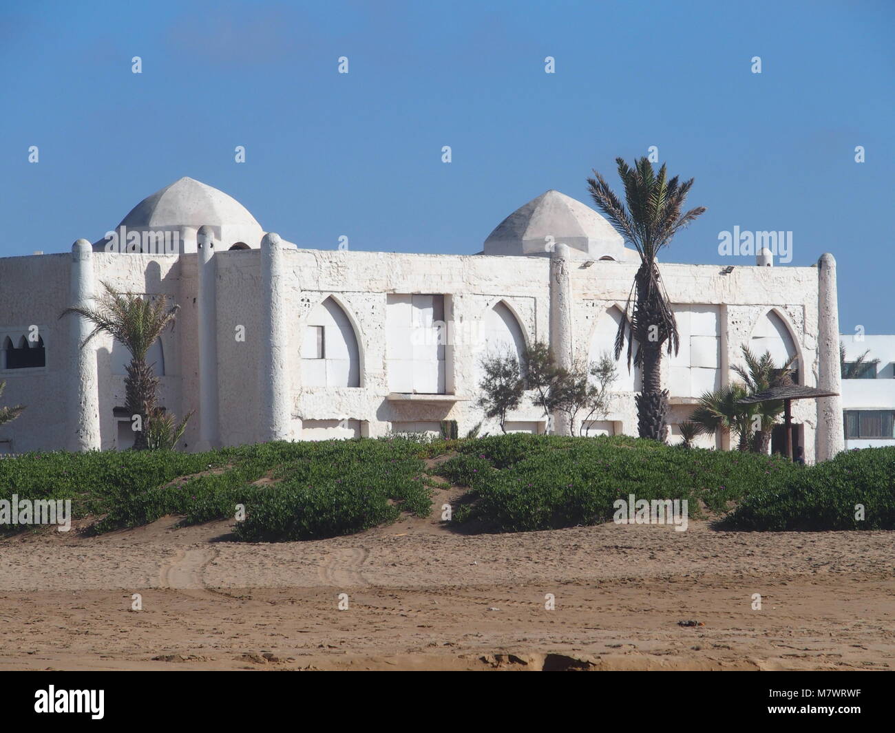 Spiaggia di mare in viaggio la città di Agadir in Marocco con il bianco hotel moderno edificio e palme nella bellezza di posti a sedere esterni luoghi e cielo blu chiaro in 20 Foto Stock