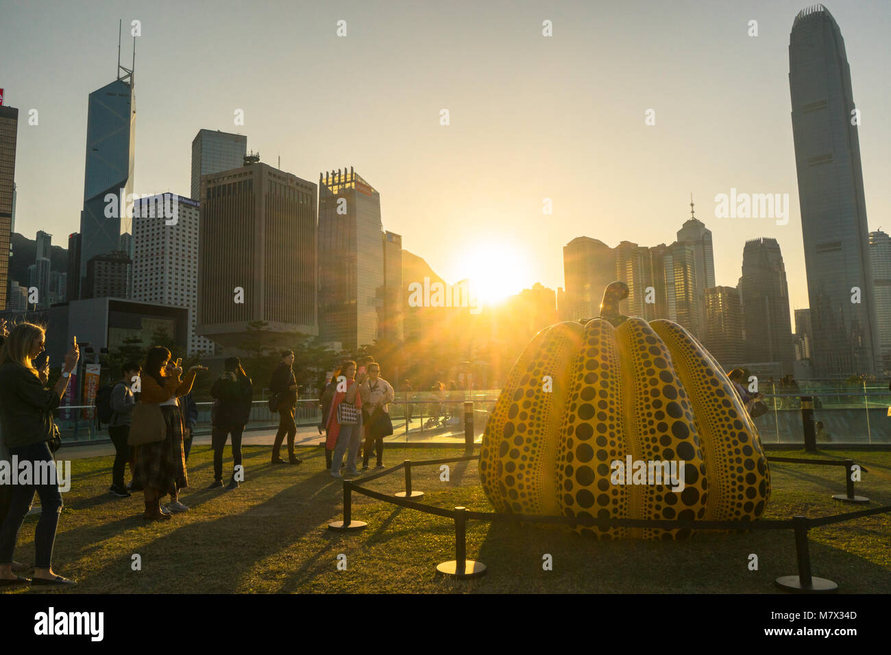Porto Arts Sculpture Park e appassionati d'arte di scattare le foto della grande scultura di zucca, skyline di Hong Kong in background Foto Stock
